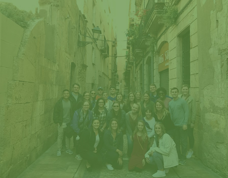 CALS Students studying abroad in Spain, posing for a group photo in the street. 