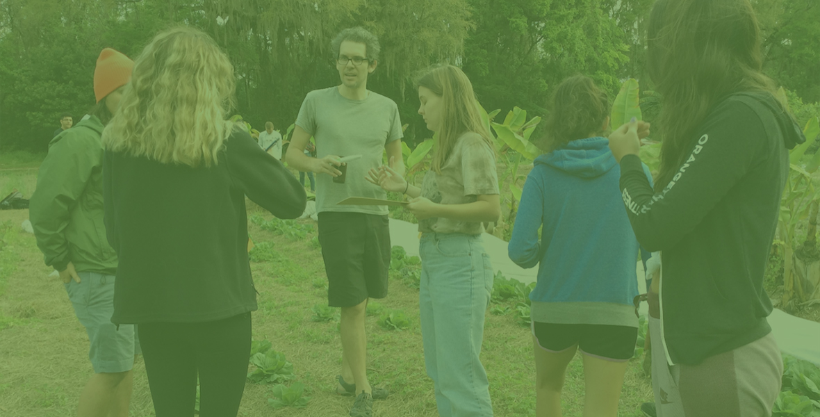 Students talking to a professor during class at the farm and gardens 