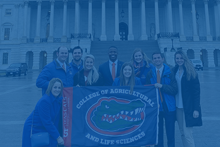 Students pose with UF College of Agricultural and Life Sciences flag in front of U.S. Capitol building.